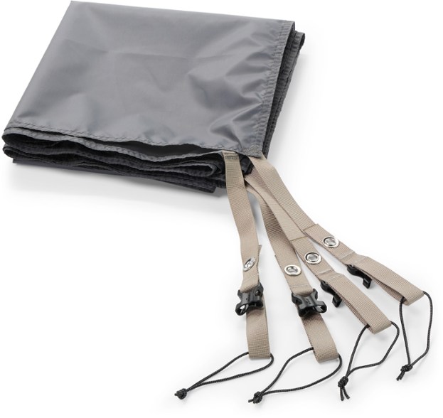 Durable REI Co-op tent footprint laid out in the forest, showing its fit under a 2-person tent.