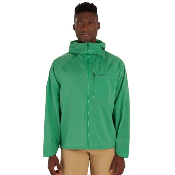 Eco-friendly lightweight rain jacket for men, displayed outdoors with scenic backdrop.