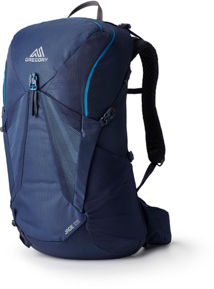 Gregory Jade 28 backpack shown on a hiking trail with lush greenery.