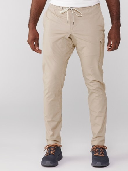 Men's adventure ripstop pants in action on a hiking trail, showcasing the tapered fit and pocket design.