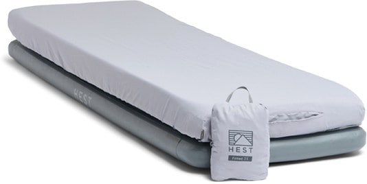 HEST TrailFit fitted sheet securely wrapped over a camping sleeping pad in forest setup
