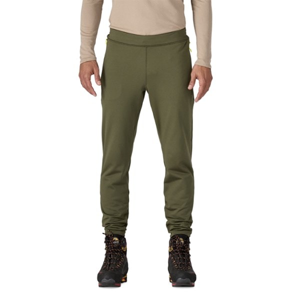 Men's Alpine Thermal Leggings displayed in a snowy mountain setting, showcasing their durable design.