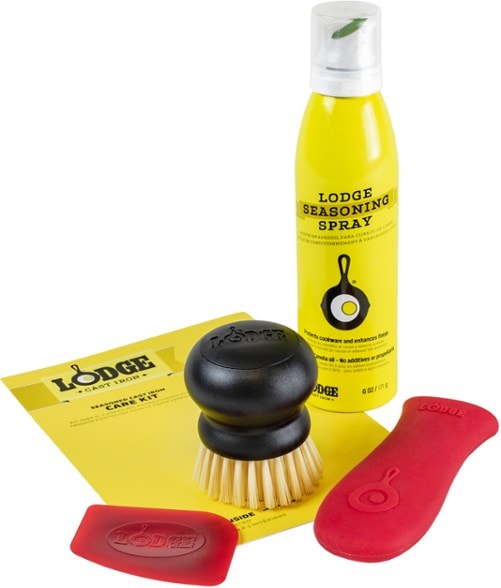 Close-up of a cast iron scrub brush with stiff nylon bristles cleaning a skillet