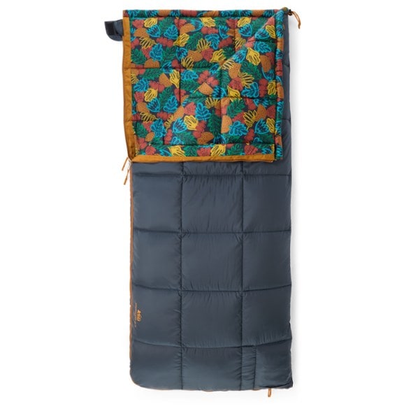 CozyCamp Kids' Sleeping Bag displayed outdoors with a campfire in the background, showcasing its vibrant design.