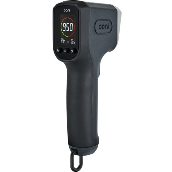Close-up of Ooni digital infrared thermometer showing backlit LCD and laser targeting the pizza stone