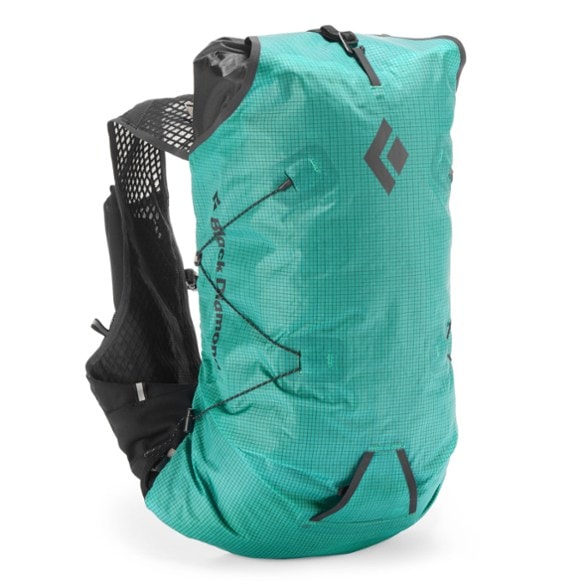 Alpine Run 15 women's backpack on a hiking trail with mountain backdrop.