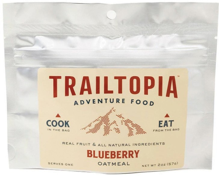 Trailblazer Blueberry Oatmeal bag displayed in the forest, highlighting natural ingredients.