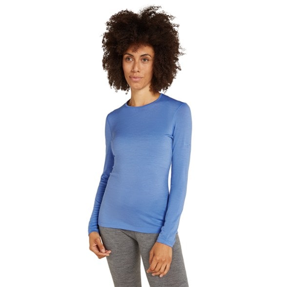 Oasis 200 women's thermal top showcasing the breathable merino wool fabric in a snowy outdoor setting.
