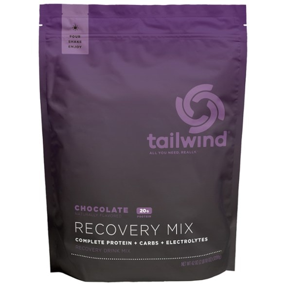 Vegan Recovery Power Mix in a clear glass with a scoop, highlighting its smooth texture and nutritional benefits.