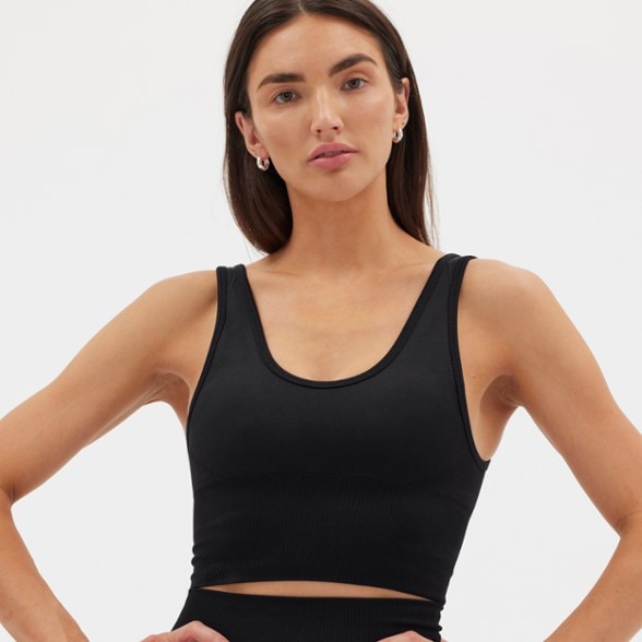 Front view of the women's eco-friendly longline performance tank top in action during hiking.