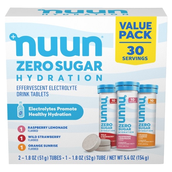 Close-up of Nuun electrolyte tablets in Wild Strawberry flavor beside fresh strawberries
