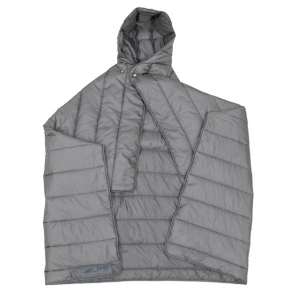 AlpineShield insulated camp blanket wrapped around camper sitting by a fire