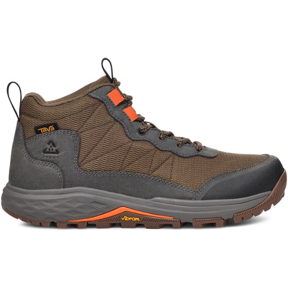Side view of men's waterproof hiking boots with Vibram soles on rocky terrain