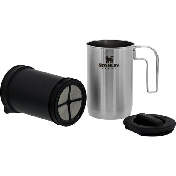 Rugged stainless steel French press set against a campsite backdrop.