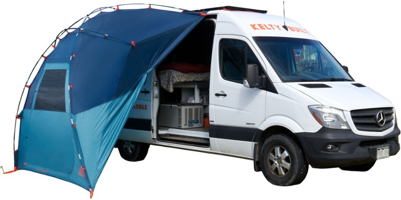 Adventure Canopy Shelter set up next to a vehicle, perfect for camping.