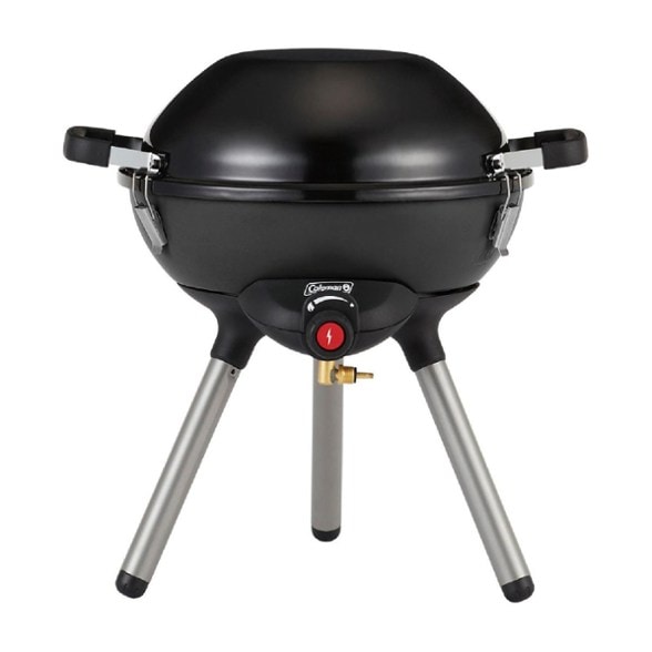 Coleman 4-in-1 camping stove with interchangeable cooktops at a campsite.