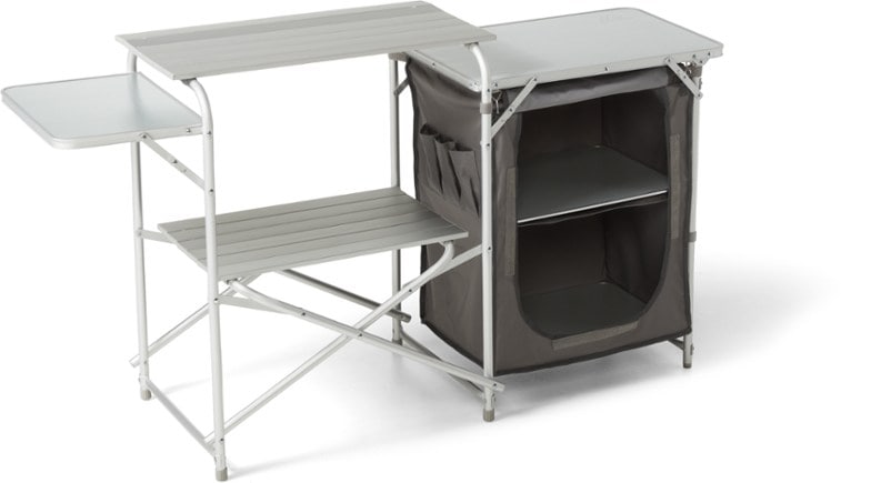 Angled view of the portable kitchen fully set up at a campsite with side tables extended