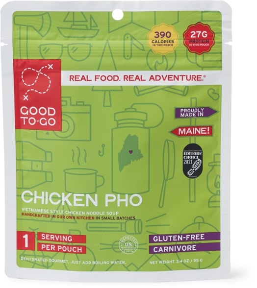 A steaming bowl of GOOD TO-GO Instant Chicken Pho served outdoors with a scenic view.