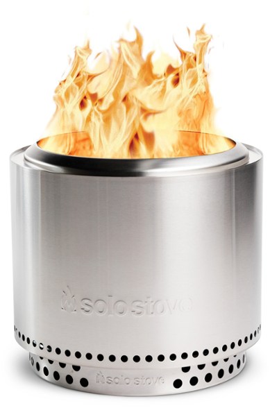 AdventureReady smokeless fire pit with a stand set up in a backyard during sunset.