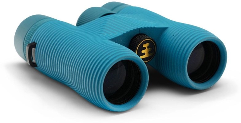 Nocs Provisions 8x32 binoculars on a hiking trail, showcasing their lightweight design.