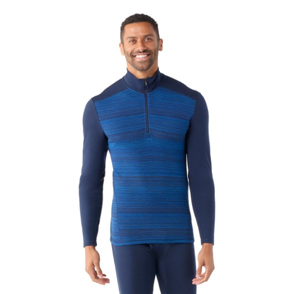 Front angle view of the men's SummitPro merino wool quarter-zip top in motion during a ski session