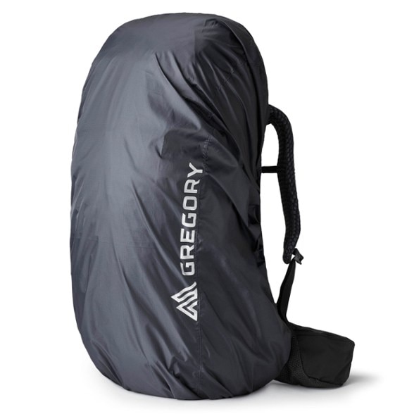 EcoShield waterproof pack cover on a 50L backpack in the rain, showcasing reflective logos and secure attachments.