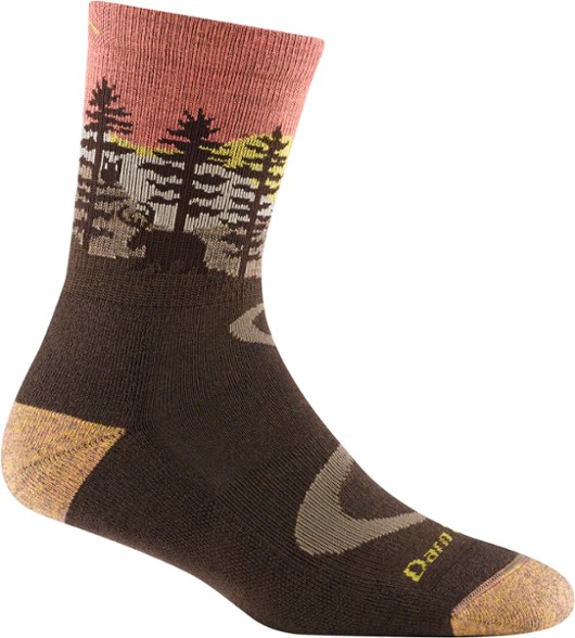 Close-up of women's crew socks worn above hiking boots on rocky trail