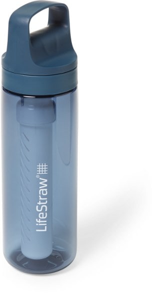Side view of the BPA-free water filter bottle outdoors beside a hiking backpack.