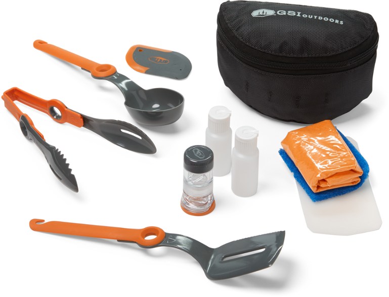 GSI Crossover Camping Kitchen Kit with utensils laid out on a picnic table