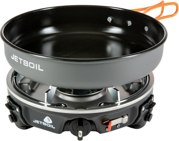 Angled shot of the Jetboil HalfGen stove setup with fry pan and windscreen on rocky terrain