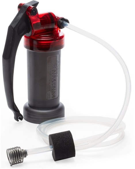 Side view of MSR MiniWorks EX Pro Pump Purifier filtering water beside a hiking trail – ideal portable water purifier