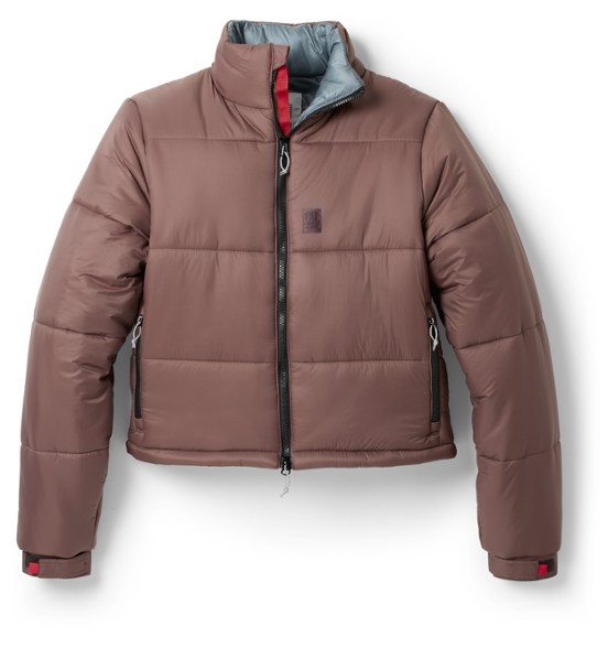 Eco-friendly women's mountain puffer jacket showing front view in snowy landscape.