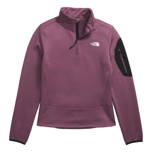 Woman wearing a quarter zip fleece jacket while hiking in the mountains.