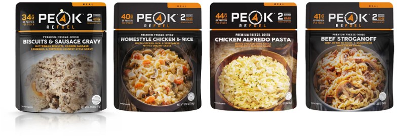 PEAK REFUEL Trail Pack 2.0 meal kit displayed with hiking gear, highlighting the real meat and premium ingredients.