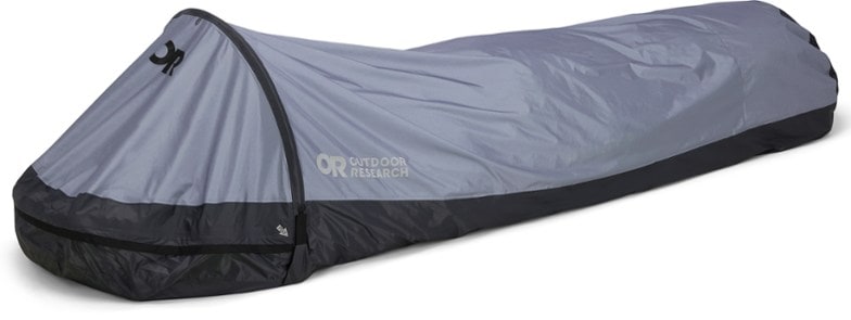 Outdoor Research Helium bivy sack set up in a forest, showcasing its ultralight design.