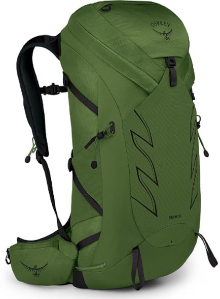 Osprey Talon 36 backpack shown in action on a hiking trail, featuring adjustable straps and a dynamic fit.
