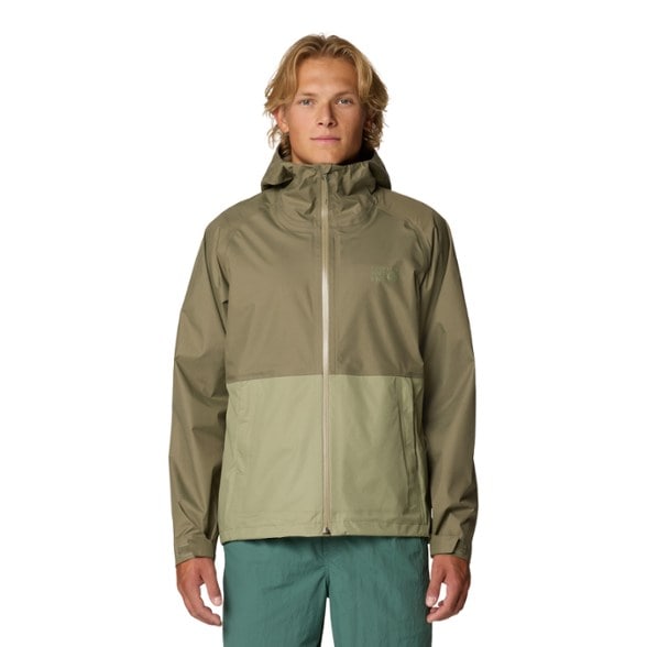 Mountain Hardwear men's waterproof jacket shown outdoors during a rain hike.