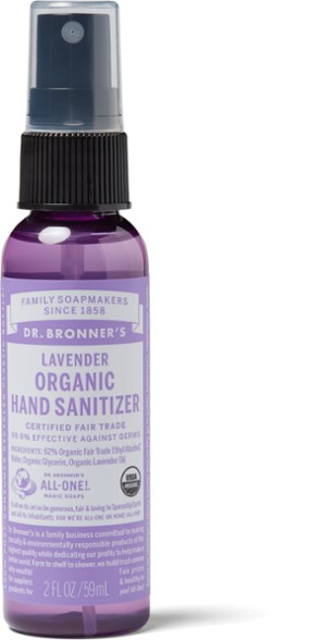 Lavender hand sanitizer bottle in a camping setting with vibrant nature background.