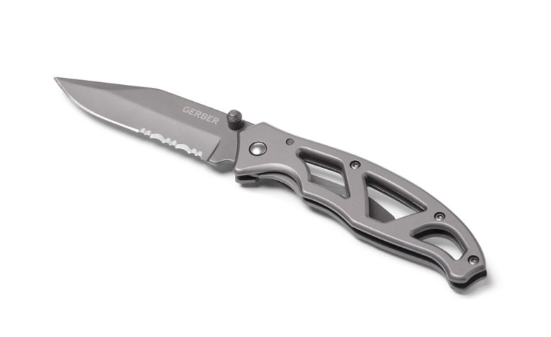 Serrated camping knife held in hand, showcasing ergonomic handle design.