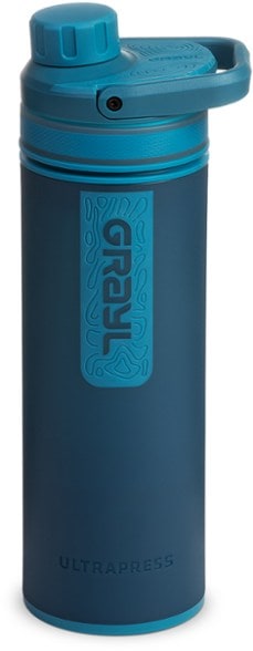 Traveler using the portable water filter bottle beside a mountain stream