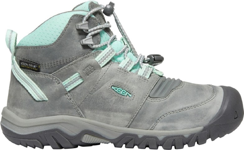 KEEN Ridge Flex Waterproof Hiking Boots for Kids, showcasing flexibility and ankle support on a rocky trail.