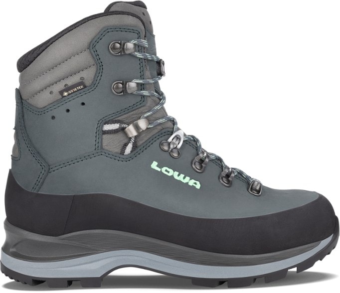 Lowa Women's Tibet Evo GTX Hiking Boots showcasing the waterproof design in action on a rocky trail.