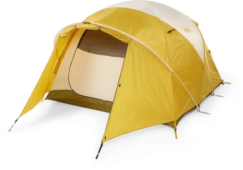 REI Co-op Base Camp 6 Tent setup in a scenic campsite, showcasing its spacious interior and vestibule storage.