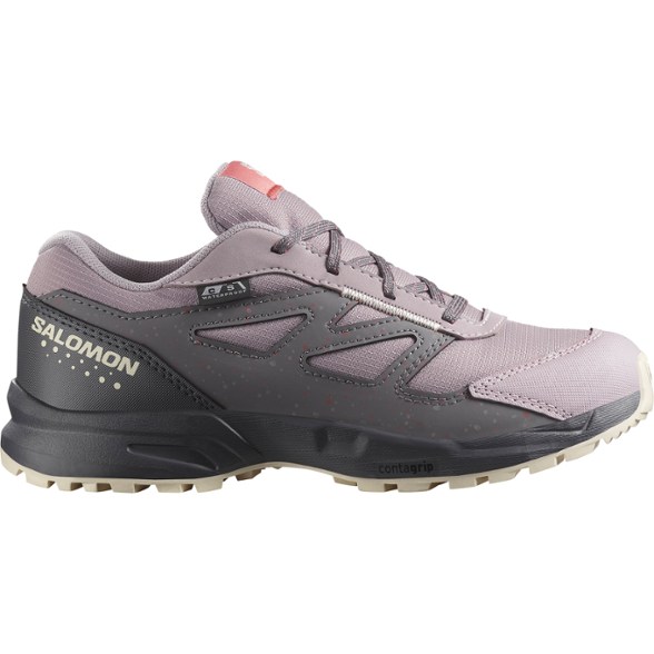 Salomon Kids' waterproof hiking boots showcasing ankle support on a rocky trail.