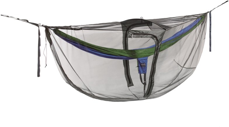 Guardian DX bug net with spreader bar set up in a lush forest, providing a bug-free space for relaxation.