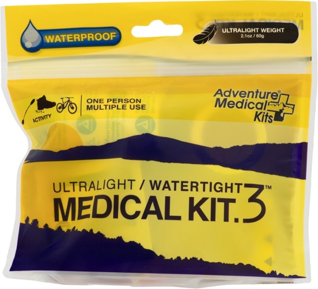 Compact ultralight medical kit laid out next to hiking boots — ideal first aid kit for solo hikers