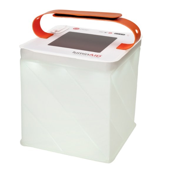 LuminAID Max Quick Inflate solar lantern glowing brightly at a campsite