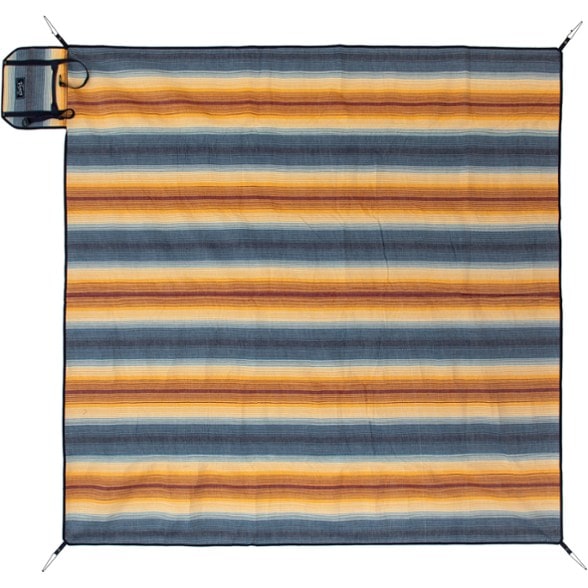 NEMO Adventure Blanket spread out on the beach showcasing its waterproof bottom and flannel top