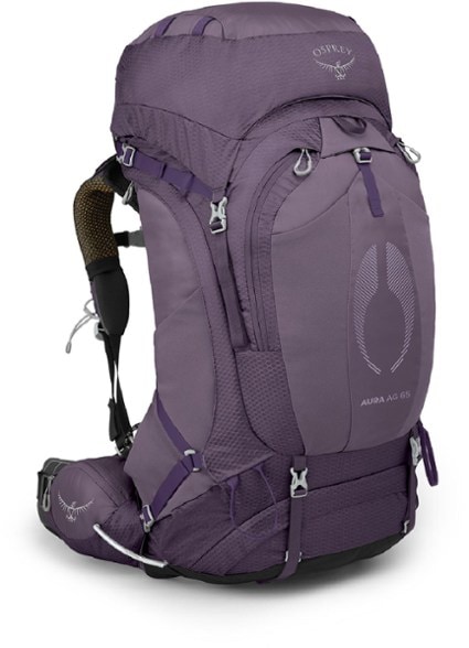 Osprey Aura AG 65 women's backpack shown on a hiking trail with scenic mountains in the background.