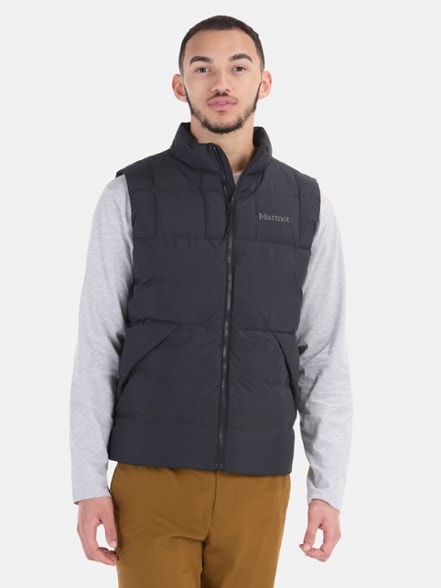Marmot Ares down vest for men in a scenic outdoor setting, highlighting its lightweight and warm features.